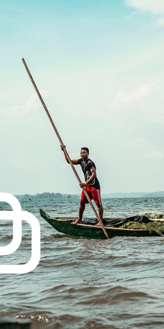 A fisherman poling a canoe across Lake Victoria